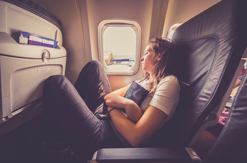 Mulher dormindo em avião